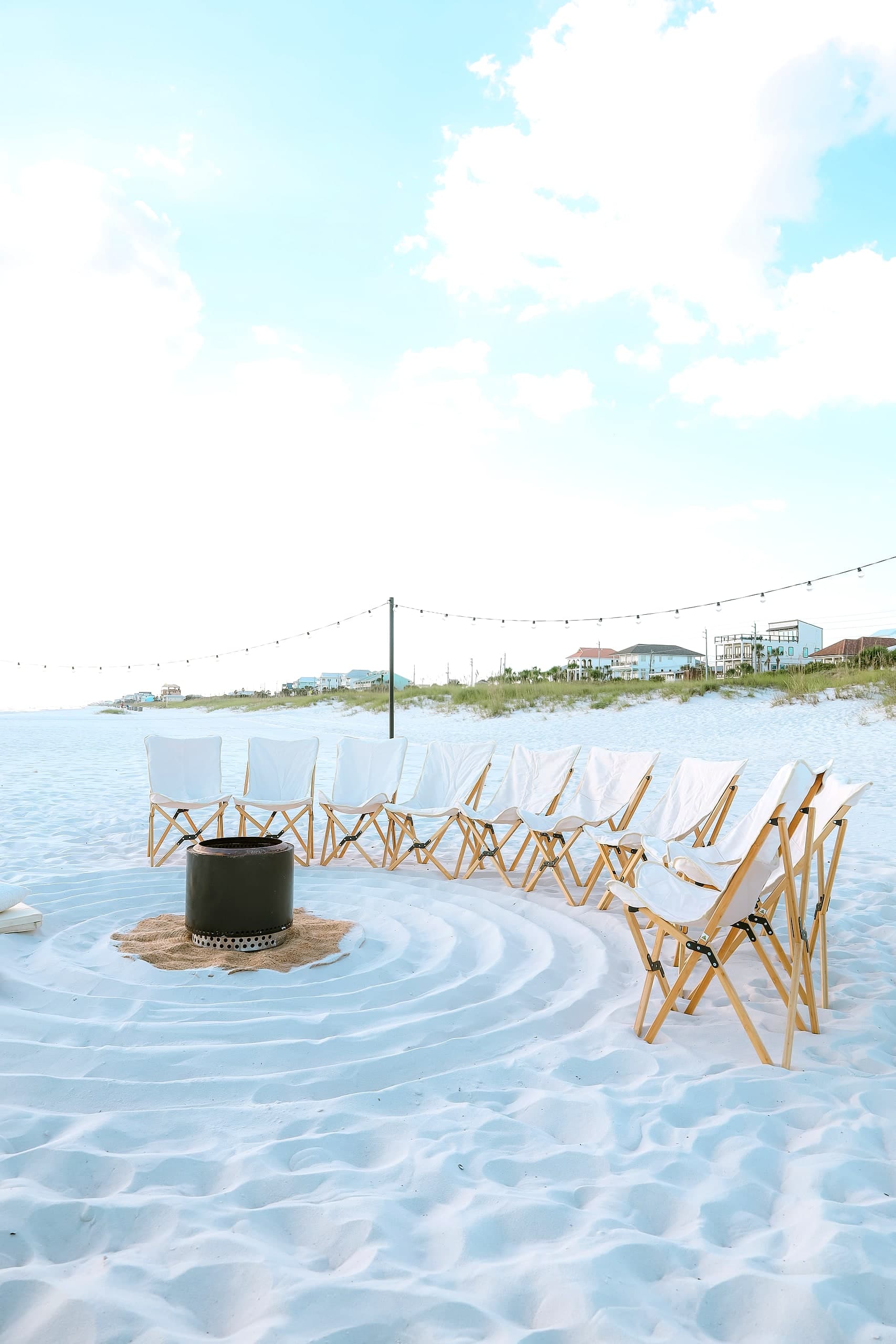 Styled chairs on the sand with the dune homes behind